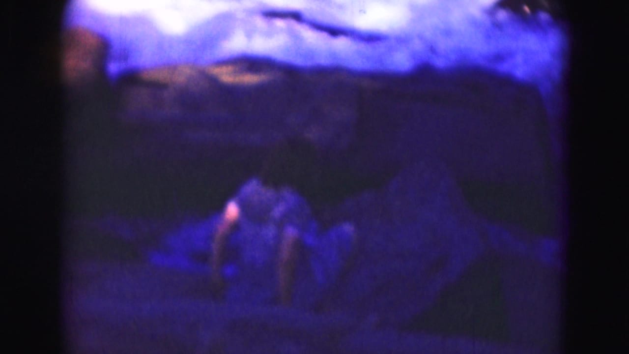 Soft 1975 8mm frame near Washington, DC with a teenage girl moving carefully across rocks by a rushing river.