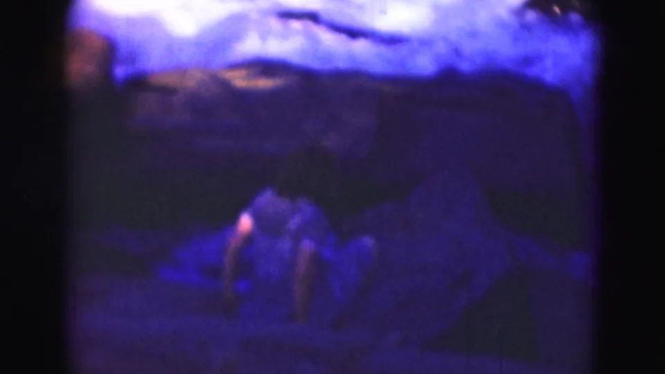Soft 1975 8mm frame near Washington, DC with a teenage girl moving carefully across rocks by a rushing river.