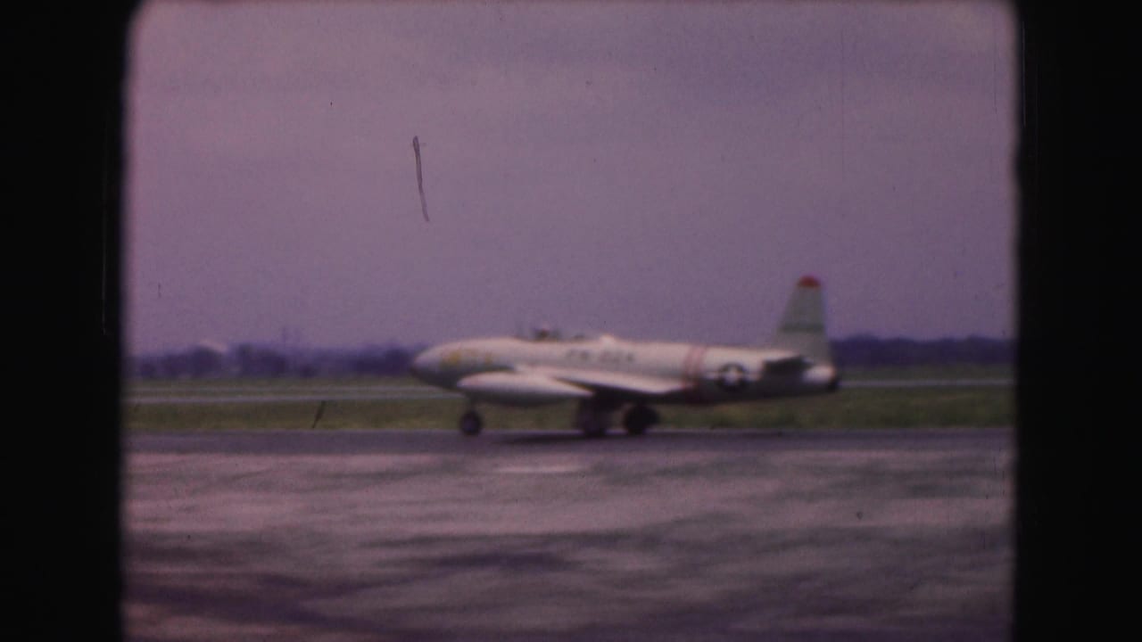 White military-marked jet continues taxiing on a runway in the 1975 Washington DC home-movie footage.