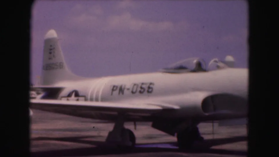 1975 Washington, DC 8mm frame showing the side of a silver military jet with PN-056 visible on the fuselage.