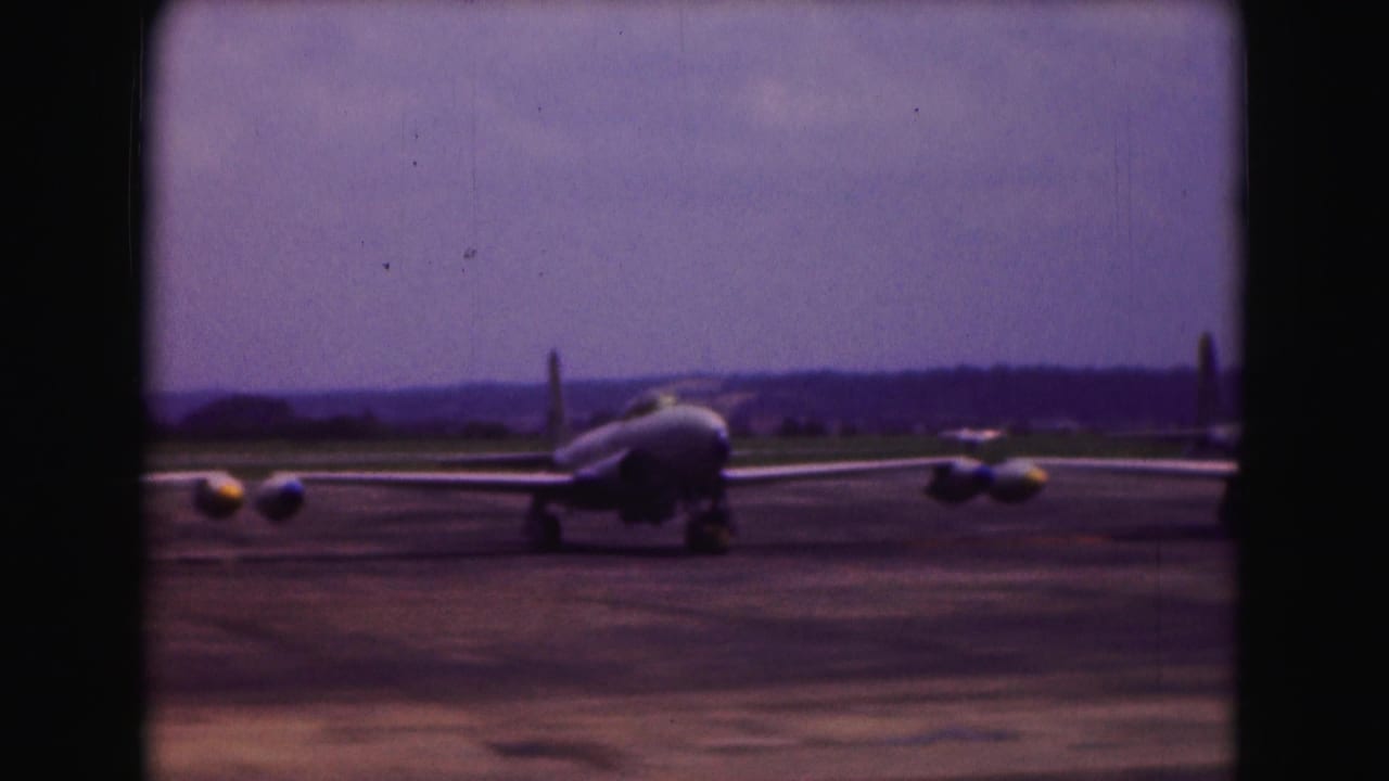 Rear view of a jet aircraft on a Washington DC airport tarmac in 1975, with distant crew and runway horizon.
