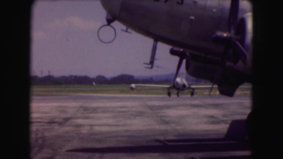 The smaller jet appears nearly head-on beneath the foreground aircraft, framed by dark 8mm contact-sheet borders.