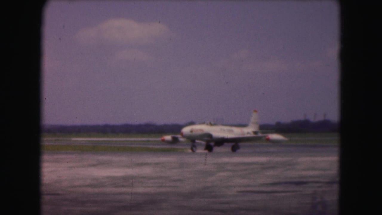 1975 Washington DC frame of a white USAF jet turning across the runway, seen from a distant spectator viewpoint.