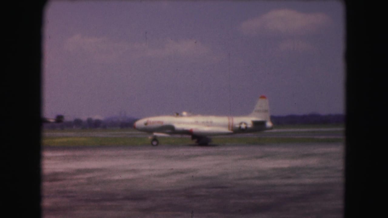 White jet taxiing on a runway under a hazy sky.