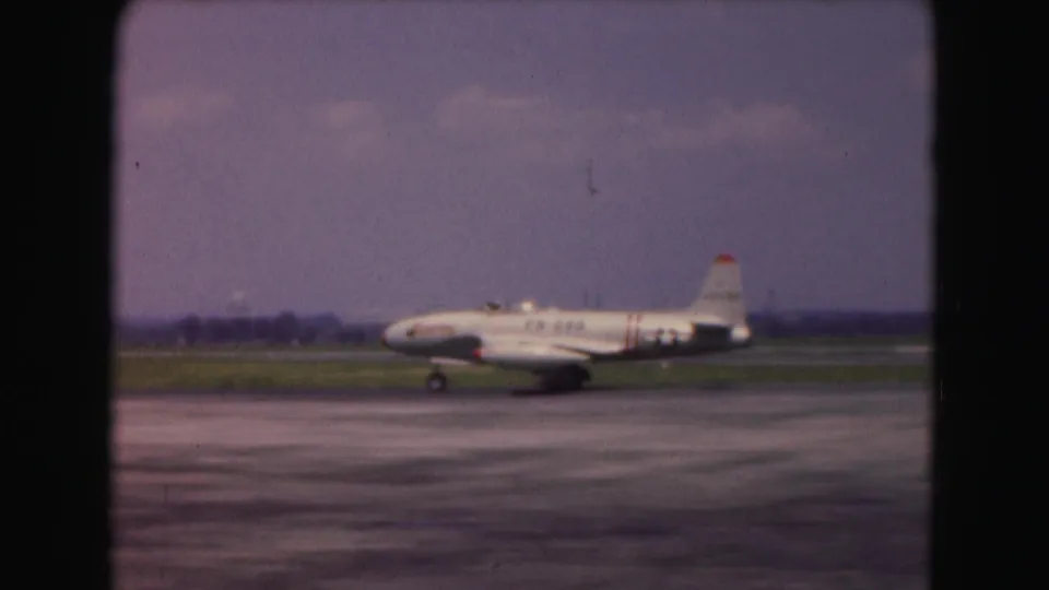 A white jet with U.S. Air Force style insignia appears in profile while taxiing at a Washington-area airport in 1975 footage.