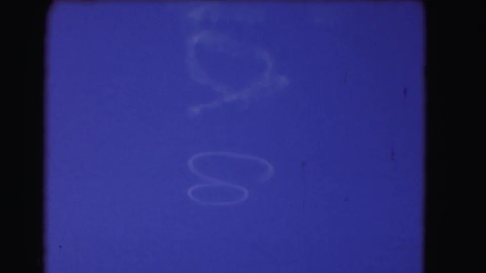 Blue sky and pale cloud traces appear within a dark 8mm frame, with visible color shift and soft exposure.
