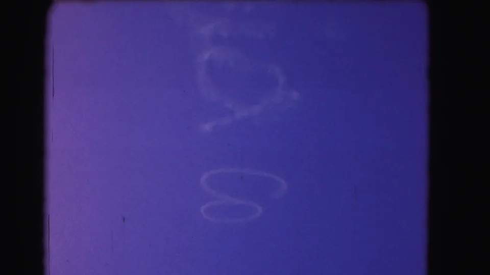 A blue-purple sky field shows faint cloud formations and rounded light shapes, captured with visible 8mm grain and frame edges.