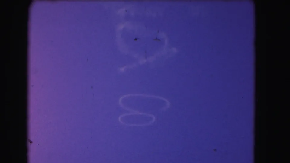 Purple-blue sky with faint wispy clouds and small film specks appears in the closing 8mm frame from the 1975 Washington, DC clip.