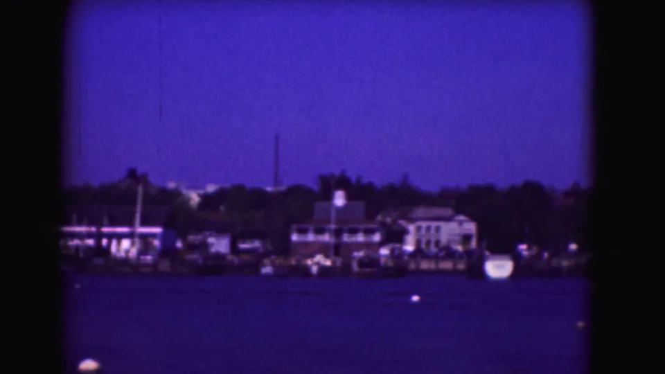 1975 8mm view likely in Washington, DC, showing a distant shoreline with buildings and trees across blue water.