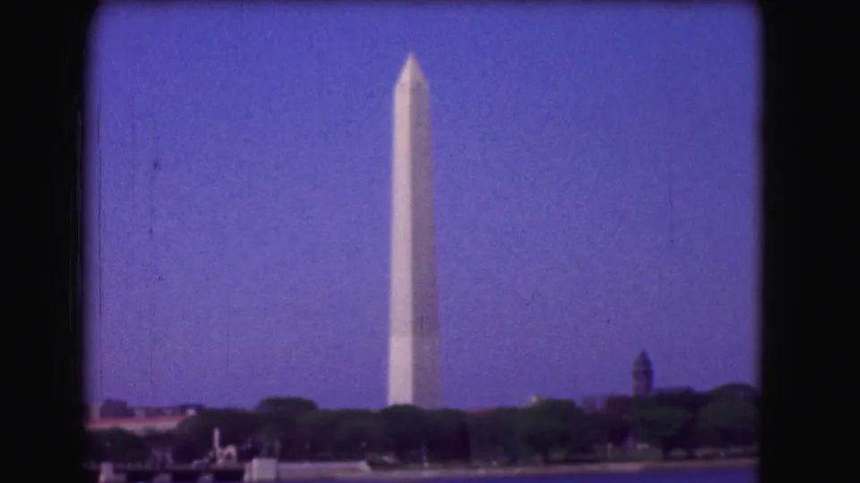 1975 Washington, DC home-movie frame of the Washington Monument seen from across a tree-lined area.