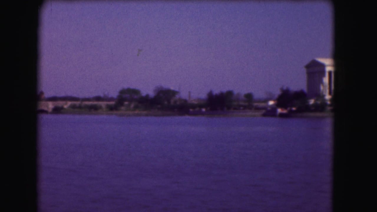 Jefferson Memorial partly visible across water under a blue sky.