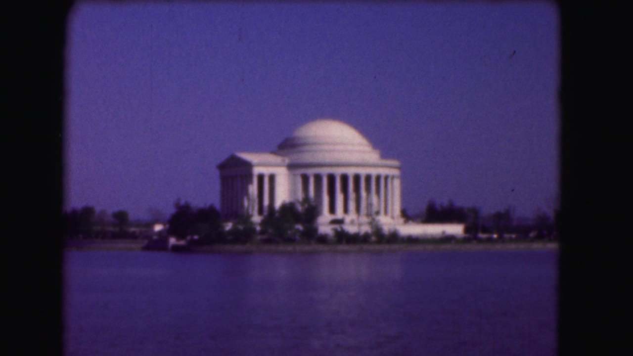 Jefferson Memorial across water with trees along the shoreline.