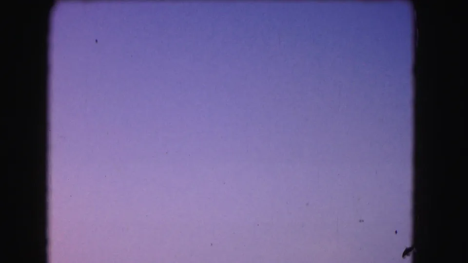 1975 8mm Washington, DC clip frame showing an abstract purple-blue twilight sky gradient with dark rounded film edges.