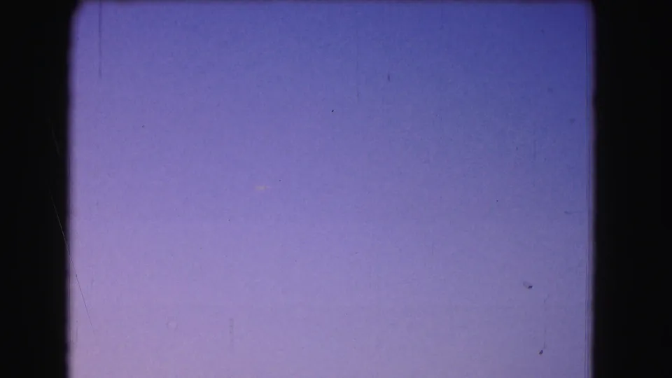 1975 Washington, DC 8mm frame with a blue-purple twilight field, slight exposure variation, grain, and visible film-frame edges.