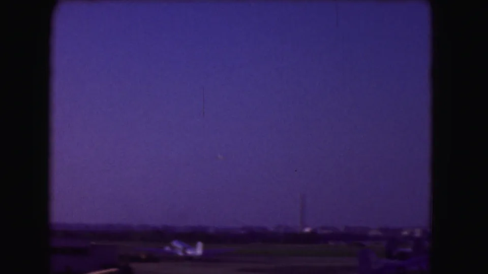 The Washington Monument rises near the lower frame beneath a dark purple dusk sky in the 1975 home movie.