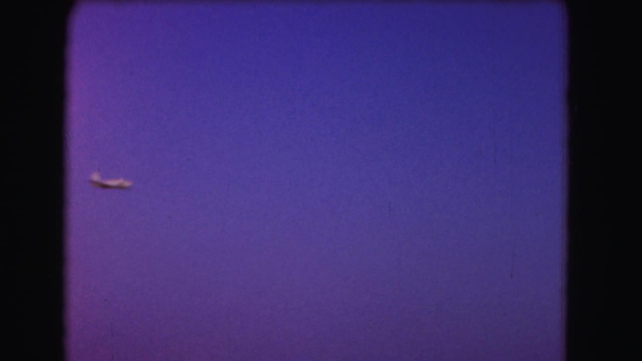 Small aircraft centered against a broad blue-purple sky.