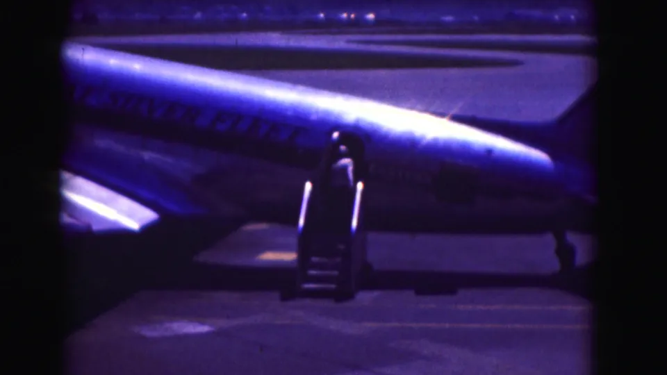 1975 Washington DC frame with portable stairs at a Pan Am aircraft door, the fuselage lettering visible in blue night exposure.