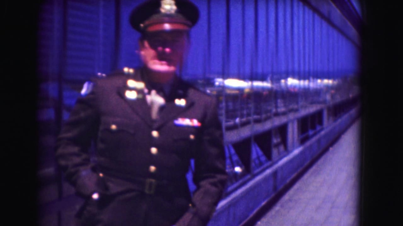 Uniformed police officer standing on a blue-lit platform beside railings and wall panels.