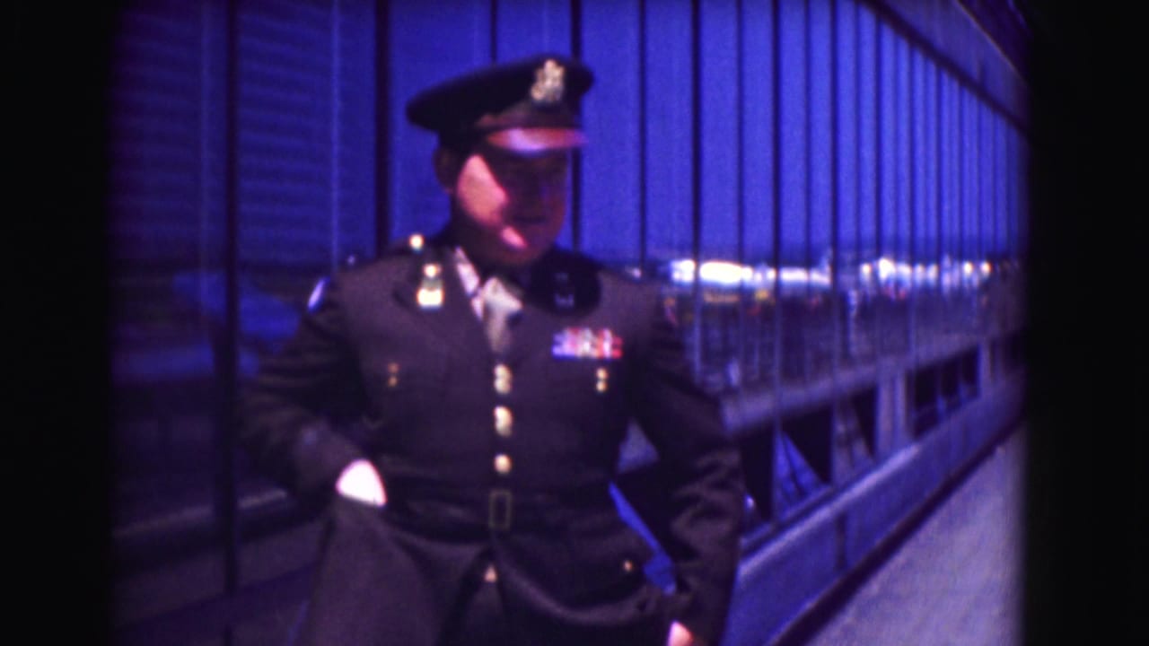 Police officer in dark uniform turning slightly with one hand near his pocket on a platform.