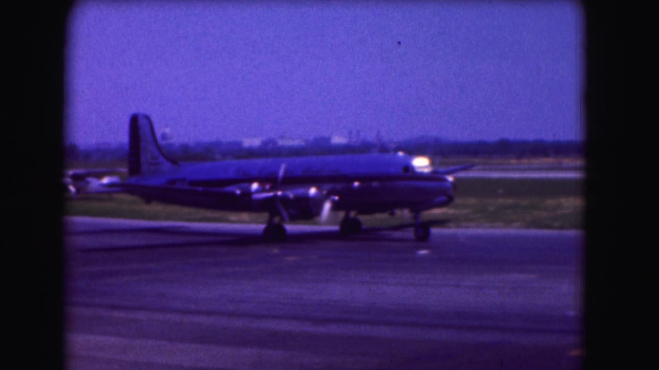 Side view of a propeller airliner taxiing on airport pavement.