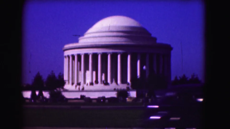 1975 Washington, DC frame of the Jefferson Memorial with lawn, trees, visitors, and a car passing in the foreground.