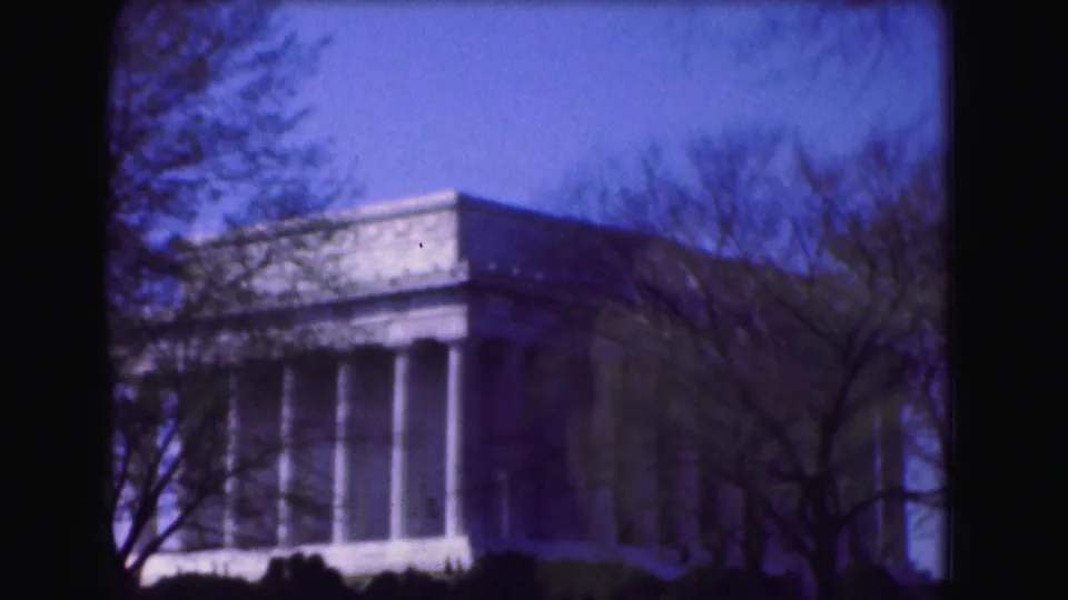A final 8mm frame shows the Lincoln Memorial in Washington DC, softened by film grain and tree silhouettes.