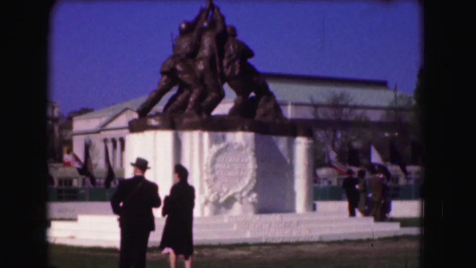 1975 Washington, D.C. frame of the Marine Corps War Memorial, with silhouetted visitors and flags around the monument.
