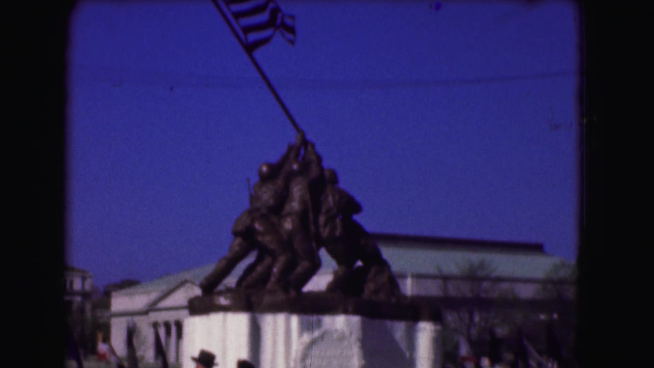 Iwo Jima Memorial sculpture with an American flag against a blue sky.