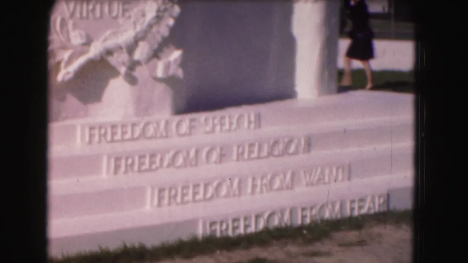 1975 Washington, DC 8mm frame showing freedom inscriptions on the monument base with a distant visitor near the edge of the shot.