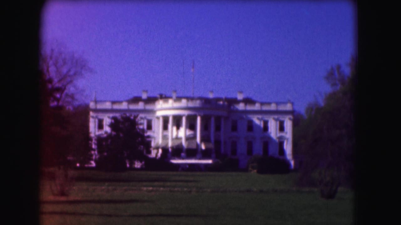 1975 8mm view of the White House in Washington, DC, seen from across the lawn with trees framing the building.