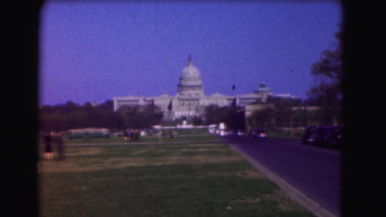 Distant U.S. Capitol across the National Mall with grass, road, cars, and pedestrians.