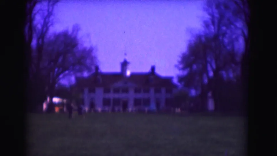 A 1975 Washington, DC 8mm view of the mansion-like exterior, with bare trees, a wide lawn, and small figures near the building.