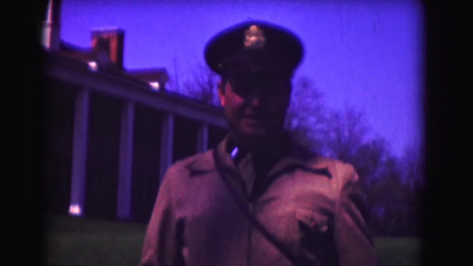 Closer 1975 Washington, DC frame of a uniformed man facing the camera, with columns and trees behind him.