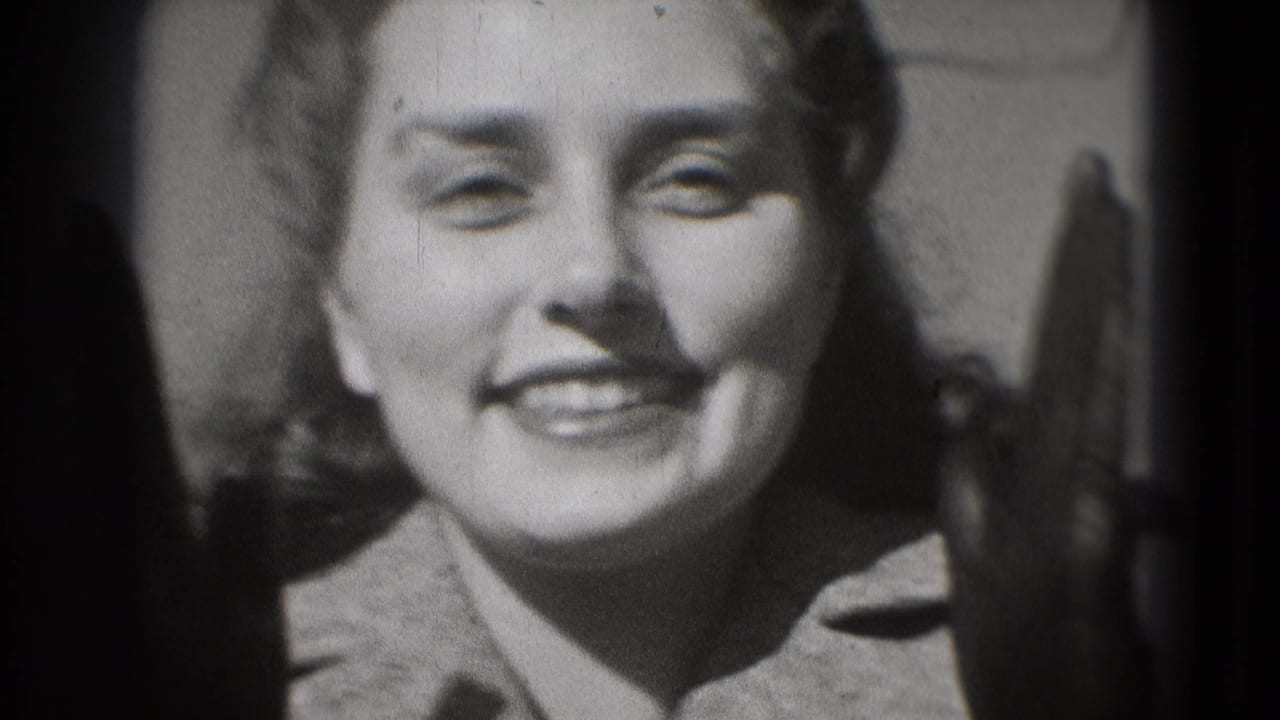 Close-up of a smiling woman in a coat, with heavy 8mm frame edges and soft black-and-white exposure.
