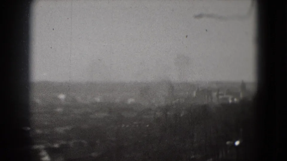 Washington, DC city panorama on 8mm film, with bare treetops, faint buildings, and a muted gray sky.