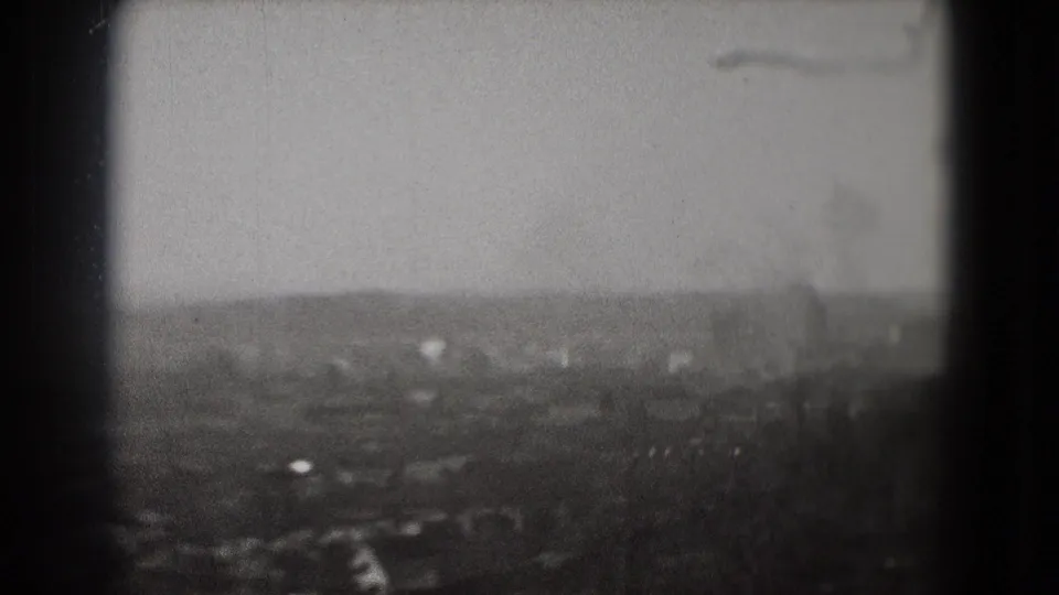 Final 1975 Washington, DC frame showing a blurred elevated panorama, treeline foreground, and faint urban forms in haze.
