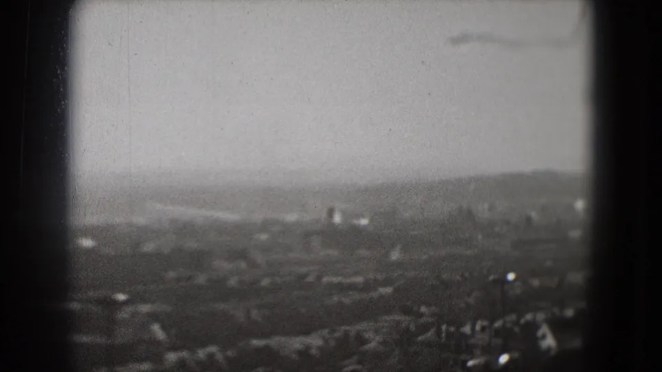 1975 Washington, DC home-movie still looking across a soft, hazy urban landscape from above.