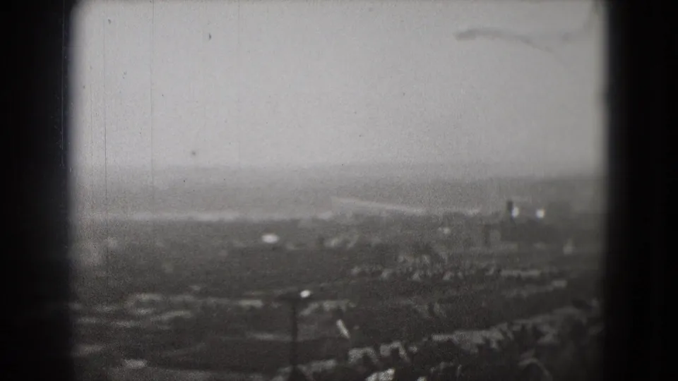 Soft 1975 Washington, DC 8mm frame showing an elevated look across roads, rooftops, and a hazy distant horizon.