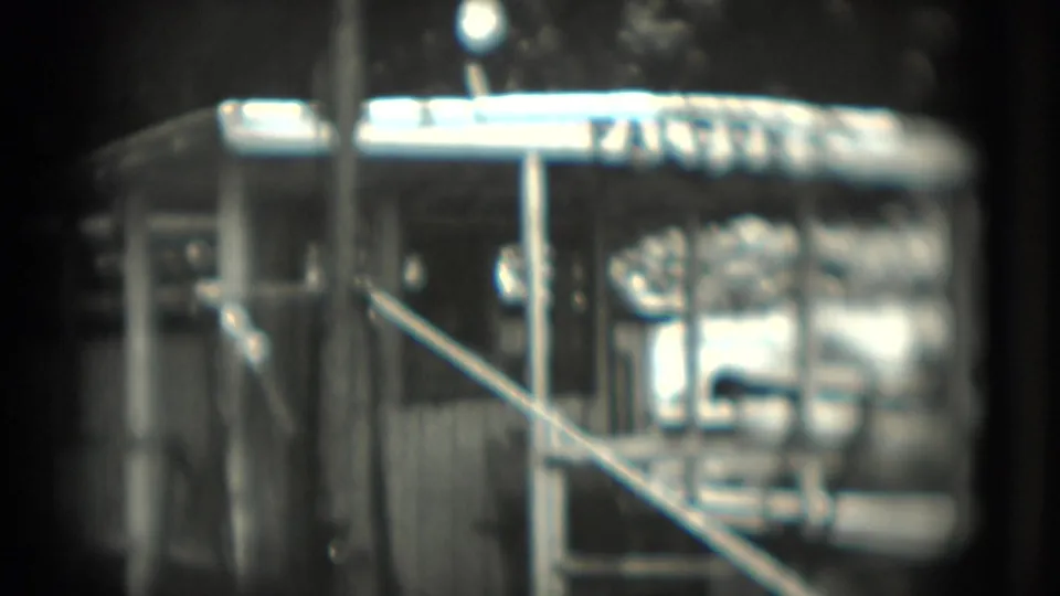 1975 Washington, DC frame showing the FALCON sign over a metal animal enclosure, with railings and strong glare from the night exposure.