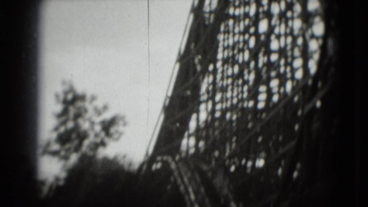Wooden roller coaster structure seen beside trees with heavy dark frame edges.