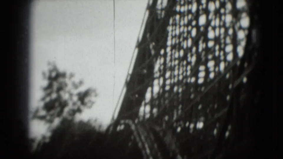 Handheld 8mm view of a wooden roller coaster structure and nearby trees, consistent with the 1975 Washington, DC clip metadata.
