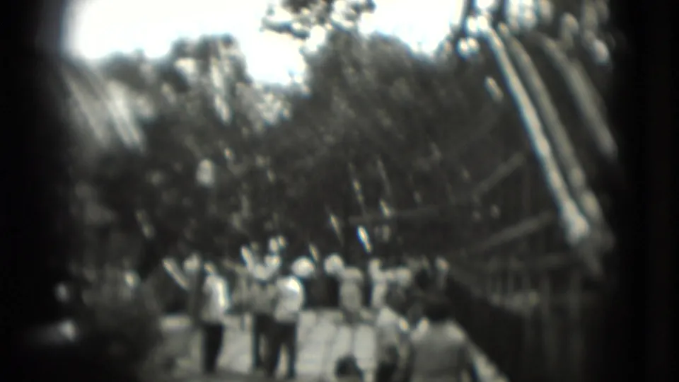 1975 8mm amusement-park view with visitors on a walkway beneath a wooden roller coaster, location supported by Washington, DC metadata.