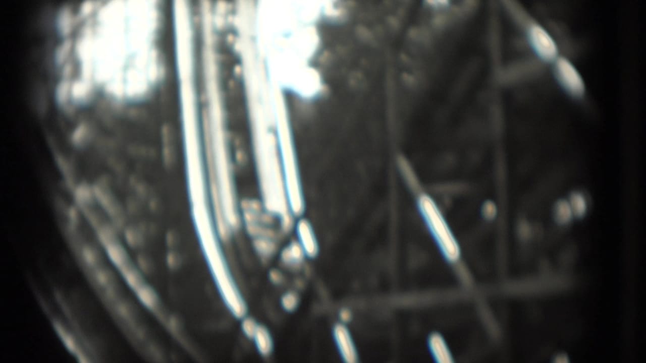 Close blurred view of rollercoaster track or car details with strong highlights.