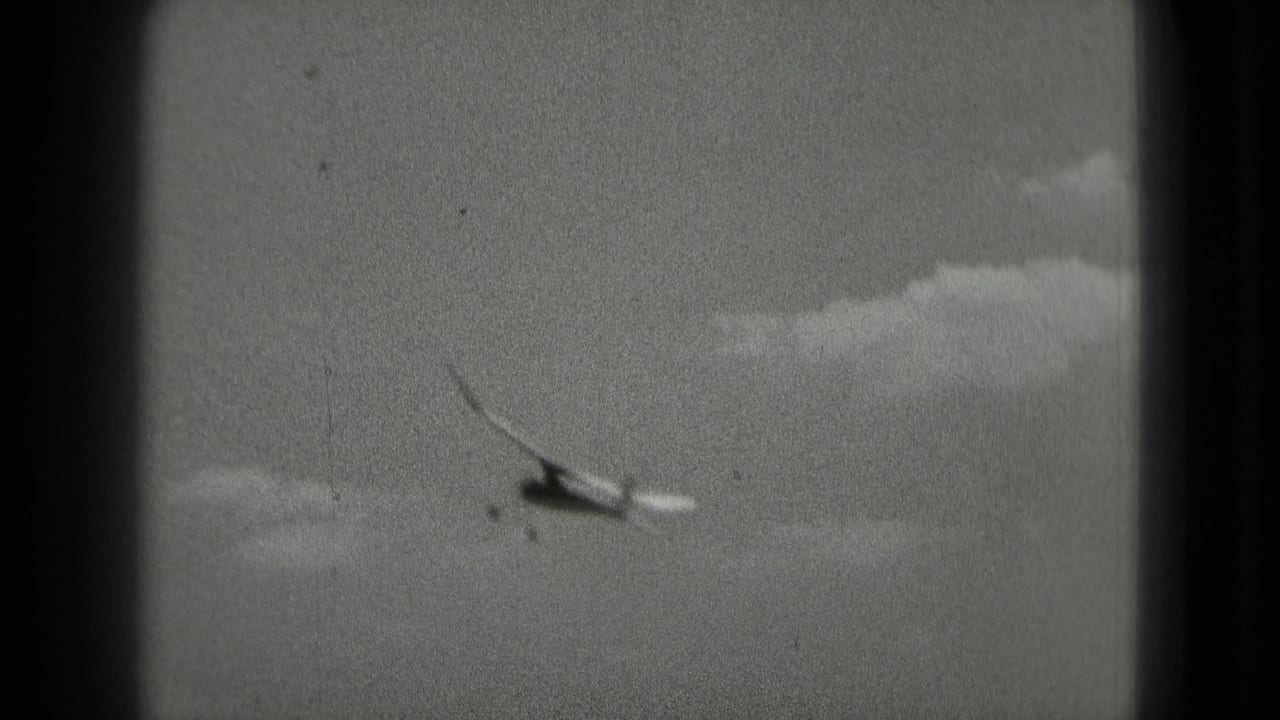 Small aircraft appears to bank through clouds in 1975 8mm home-movie footage associated with Washington, DC.