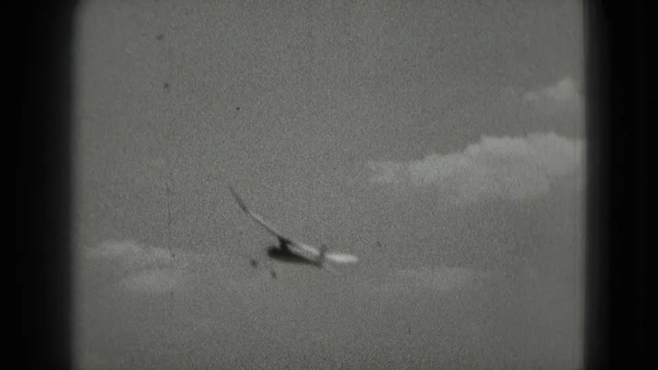 Small aircraft appears to bank through clouds in 1975 8mm home-movie footage associated with Washington, DC.