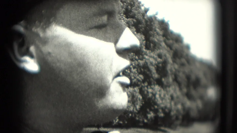 Profile close-up of a man appearing to talk or react, filmed outdoors in a grainy 1975 Washington DC 8mm home movie.