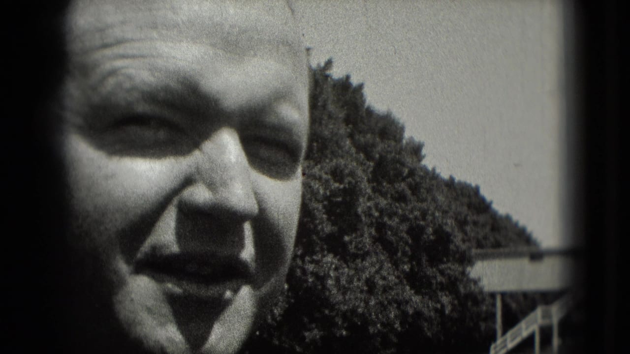 1975 Washington, DC home-movie close-up of a man in a cap smiling in bright outdoor light, with trees behind him.