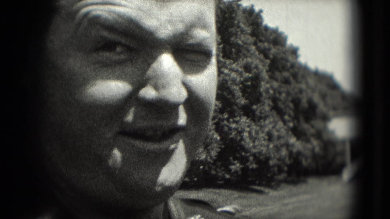 Black-and-white 8mm close-up of a man in uniform-style clothing squinting outdoors in Washington, DC in 1975.