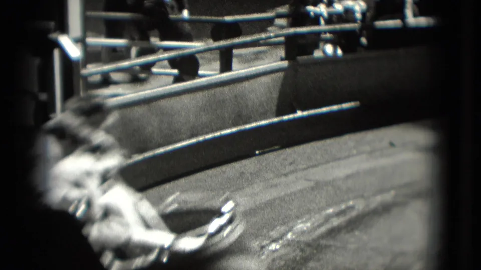 A blurred seated rider appears beside curved metal ride railings in a 1975 Washington, DC outdoor amusement setting.