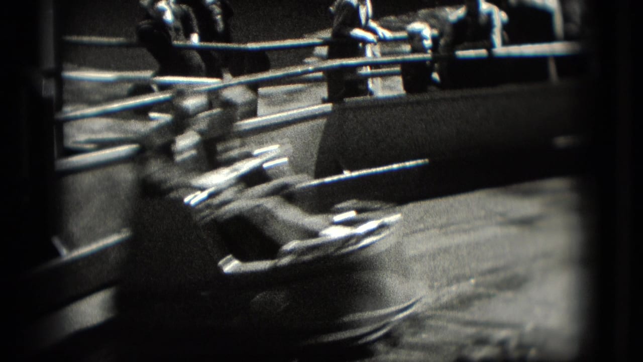 1975 Washington, DC home-movie frame showing a whip ride car sweeping past metal railings with riders visible beyond it.